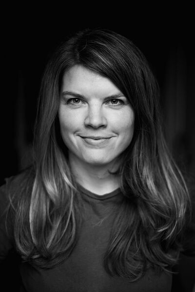 Natürliches Businessportrait einer jungen Frau in Schwarz-Weiß.